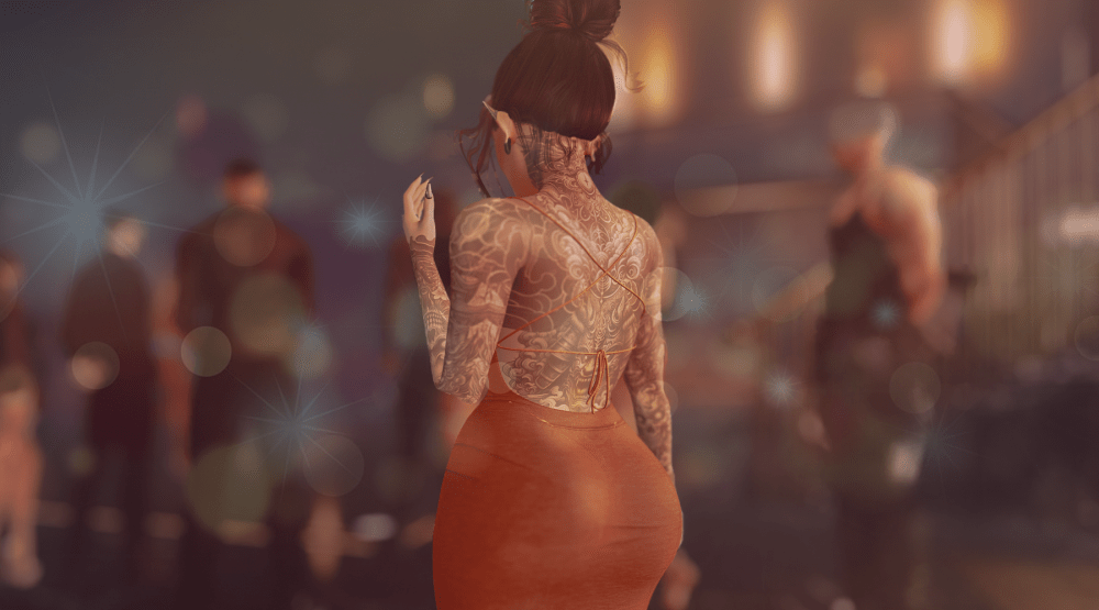 A Second Life avatar with an intricate full-back tattoo and a red halter dress stands in a softly lit club or party setting. The background is blurred, showing other avatars and warm glowing lights, creating a moody, atmospheric scene with lens flare effects.